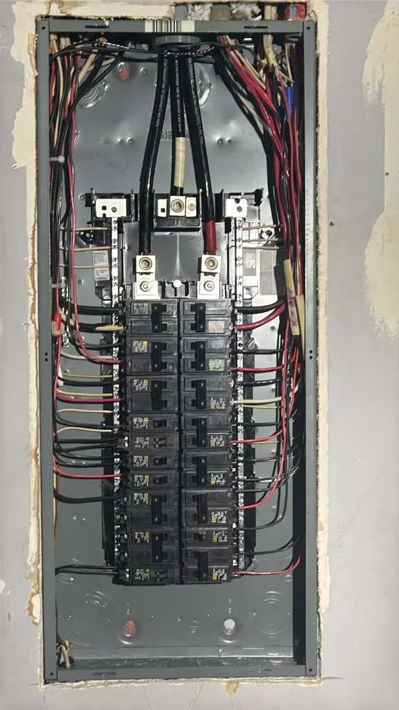 Electrical panel with breaker box, organized wiring, and disconnect switch installation